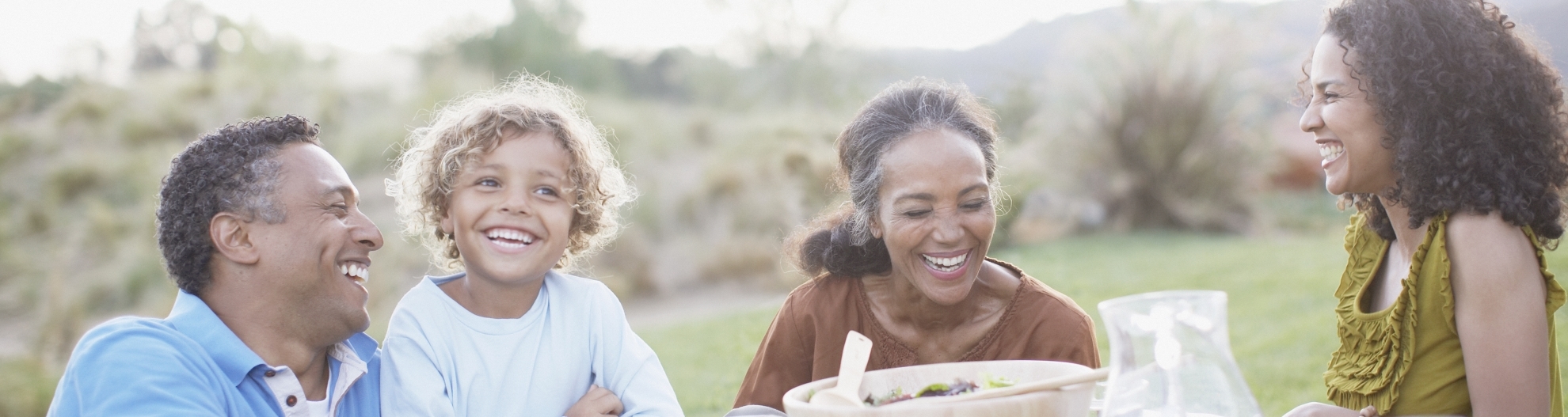 Family laughing at outdoor picnic