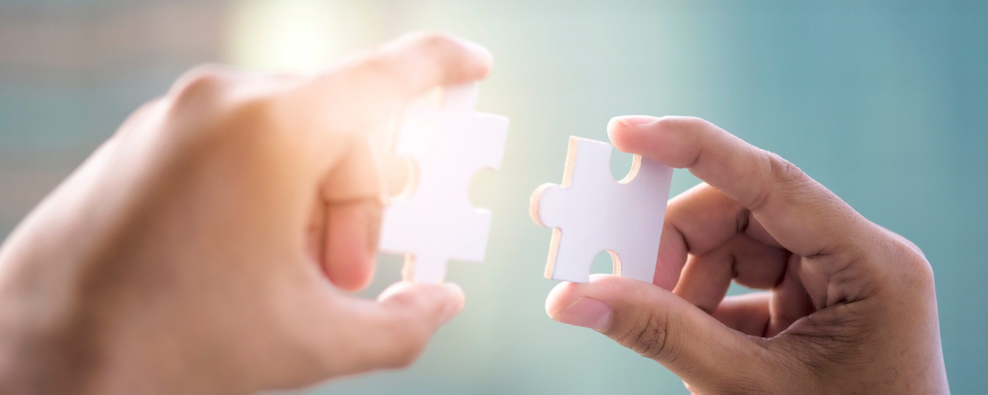 Businessman fitting puzzle pieces together