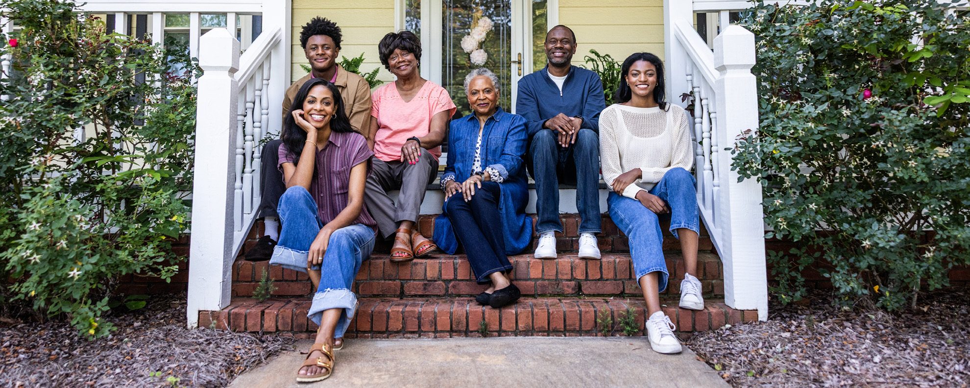 Multi-generational family sitting on porch steps