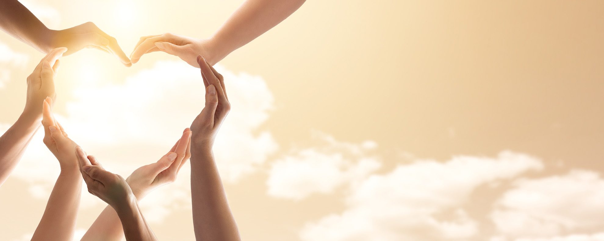 Hands forming a heart with sunlight burst in background